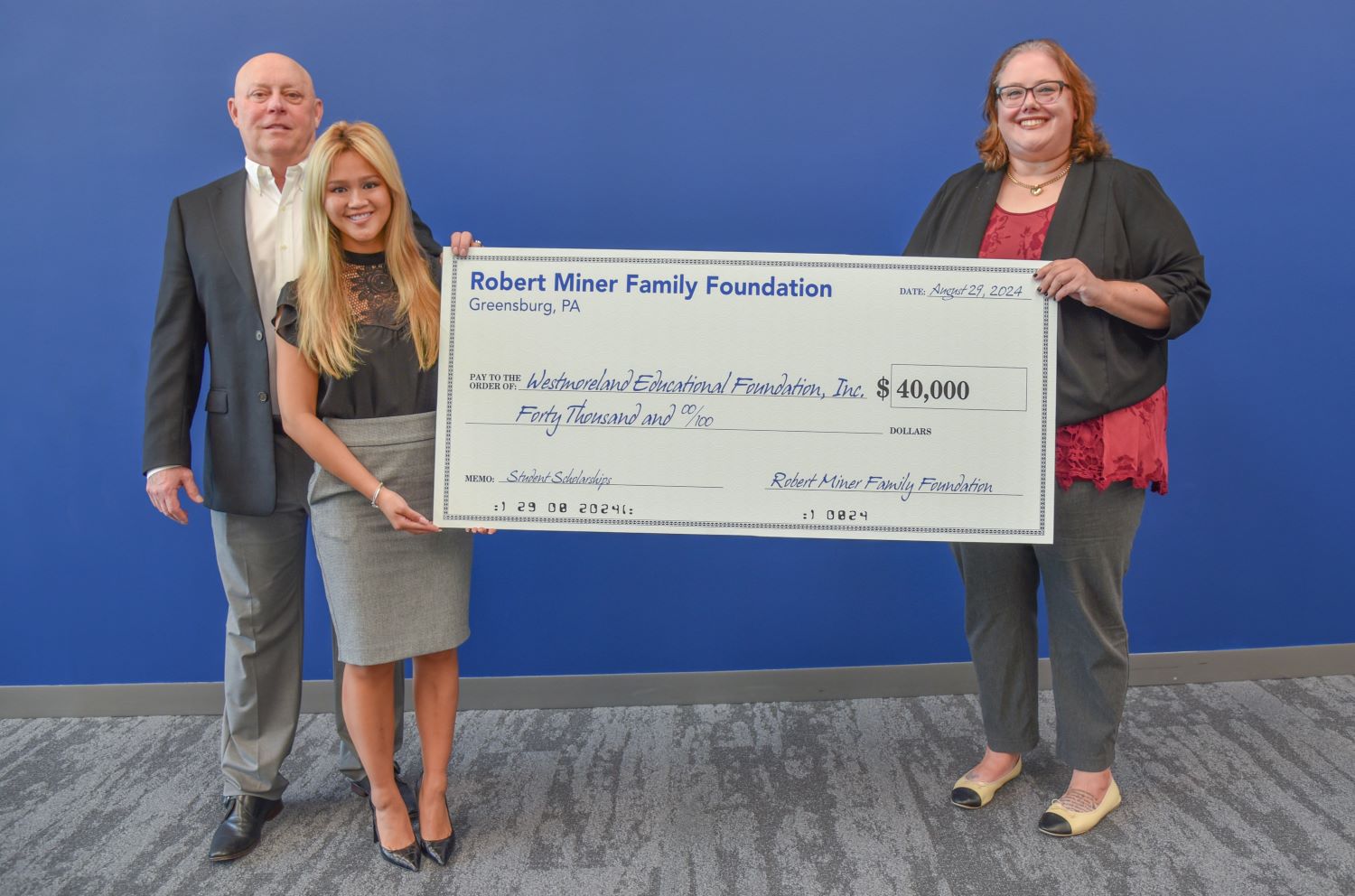 Bob and Kaylee Miner present a donation to Megan Sheesley, Executive Director of the Educational Foundation