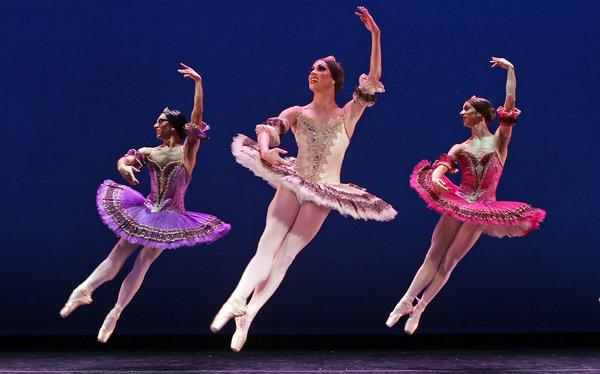 Ballerinas flying through the air across the stage.