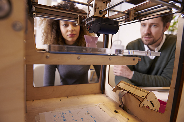 Students working with a 3D printer