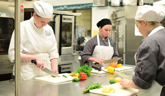 Culinary students chopping vegetables