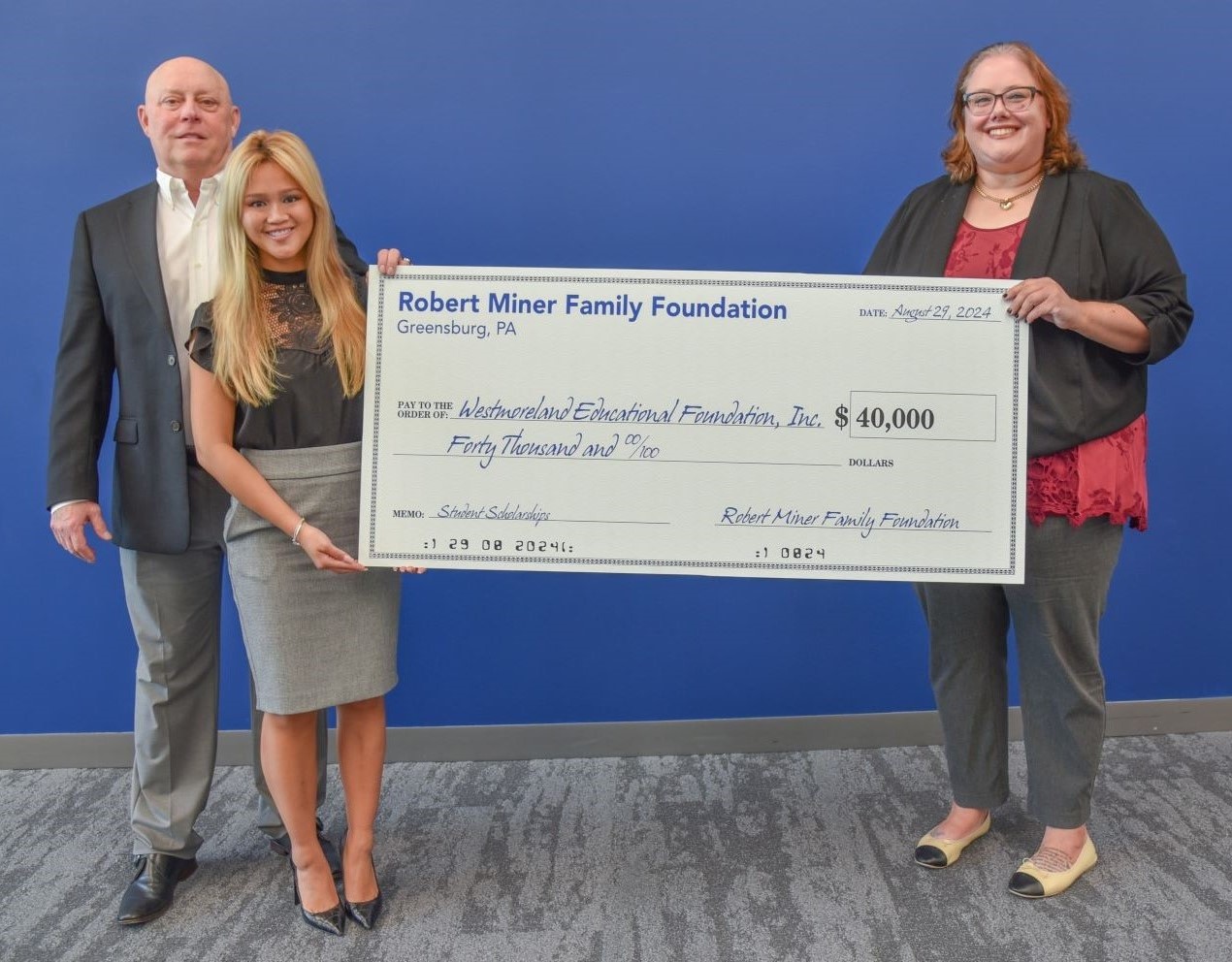 Bob and Kaylee Miner present a donation to Megan Sheesley, Executive Director of the Educational Foundation