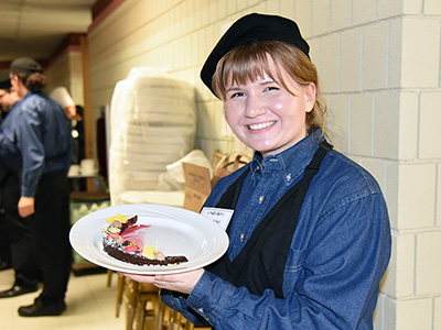 Culinary Arts student shows off dessert she prepared at Chefs' Marketplace