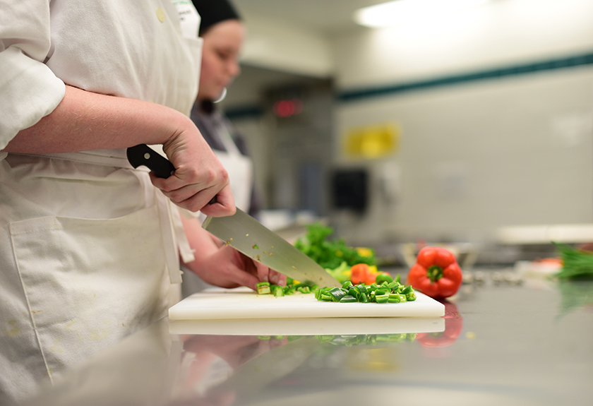 Culinary students chopping vegetables in the kitchen