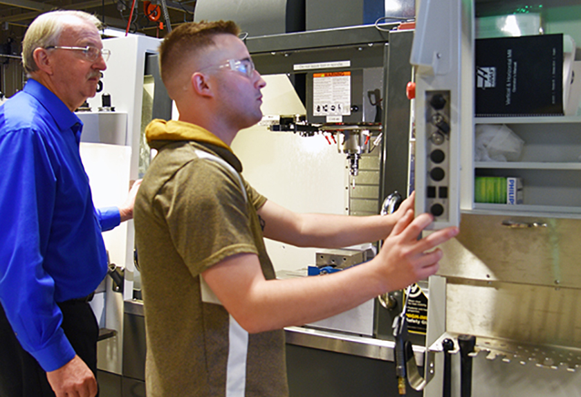 Machining instructor Dan Kepple guiding a student