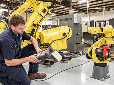 Worker checking robotics used in manufacturing